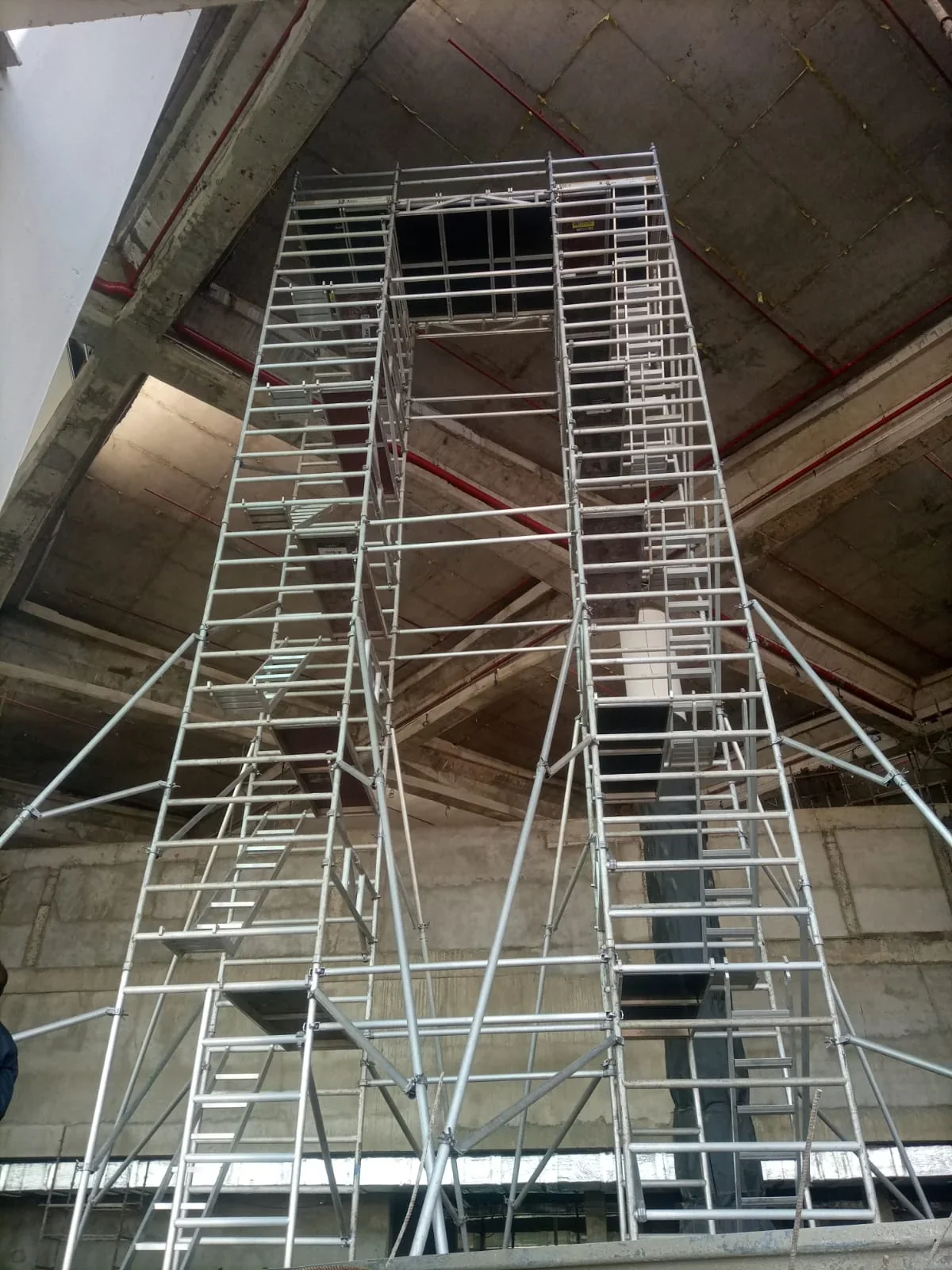 Connected aluminium bridge-scaffold towers installed below a concrete structure